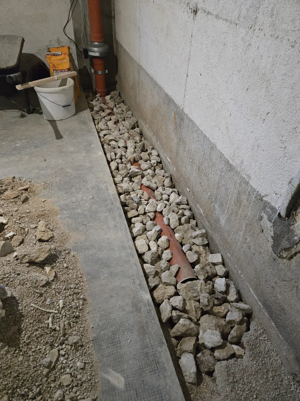 Conduite de drainage entourée de ballast avant fermeture de la dalle.